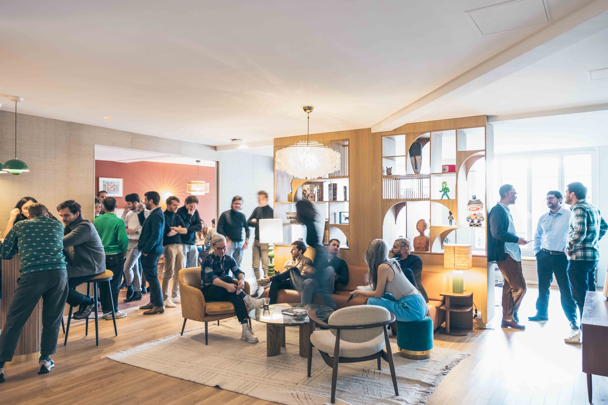Le salon de Vectors, rue Beaubourg : canapés, bibliothèque en bois et invités qui échangent